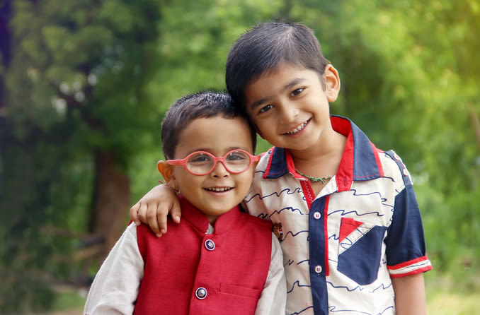 zwei Kinder, eines trägt eine Brille