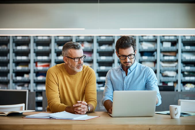 Personnes regardant un écran d'ordinateur dans un bureau