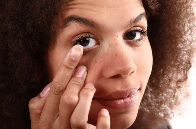 mujer insertando una lente de contacto escleral