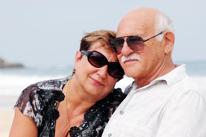 pareja de edad con gafas de sol en la playa
