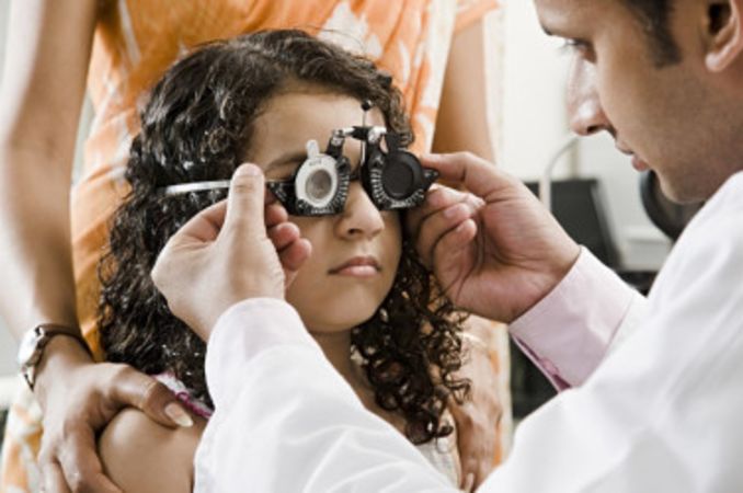 Young Indian girl getting an eye exam by an eye doctor - India