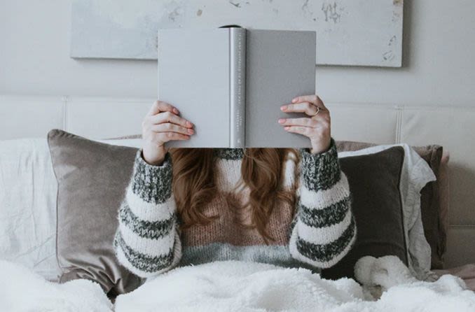 Girl reading a book up close due to myopia symptoms