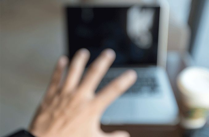 sudden blurry view of a hand reaching towards laptop