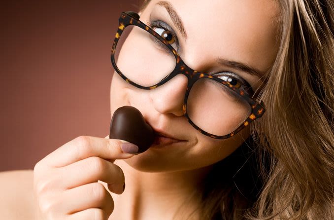 woman wearing eyeglasses eating dark chocolate