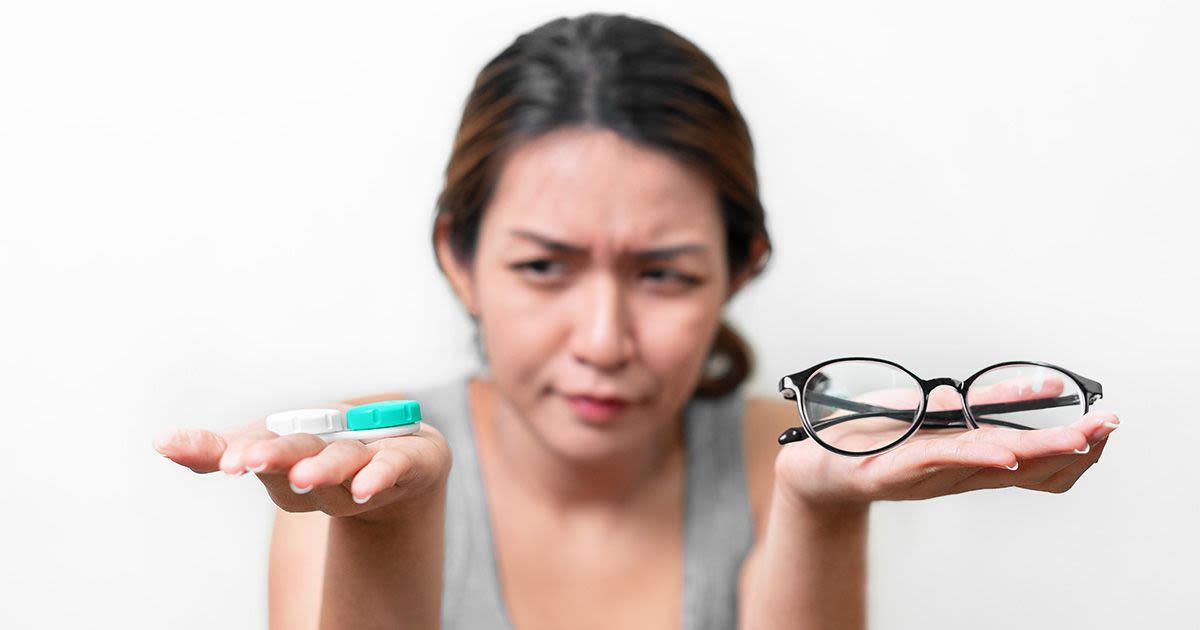 mulher decidindo entre óculos e lentes de contato