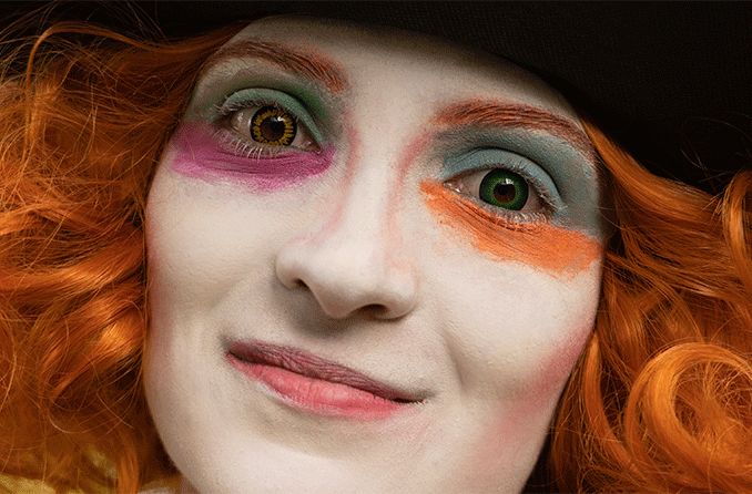 red-headed woman with costume makeup and colorful cosplay contact lenses