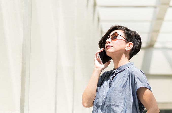 woman wearing transitions sunglasses looking up at the sun