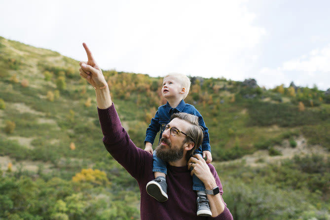 un père montre à son fils quelque chose dans le ciel