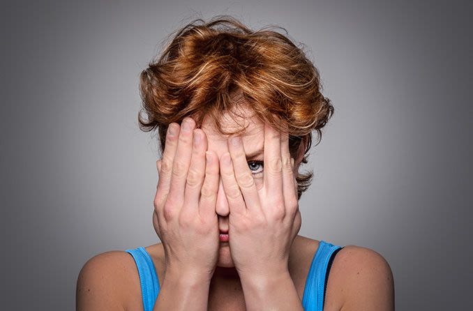 Femme avec un trouble oculaire couvrant son visage avec ses mains