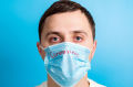 Hombre con mascarilla que tiene coronavirus y conjuntivitis