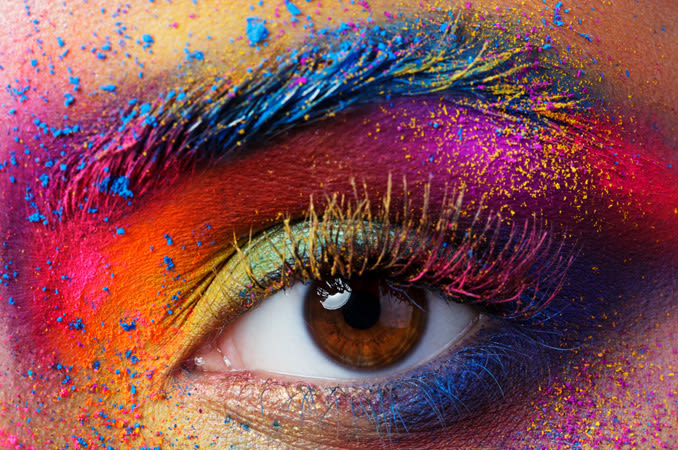 Closeup of an eye with colorful paint or makeup surrounding it