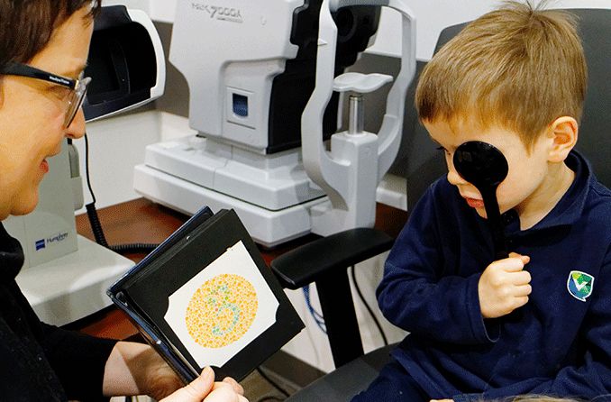 young boy getting a type of color blindness test