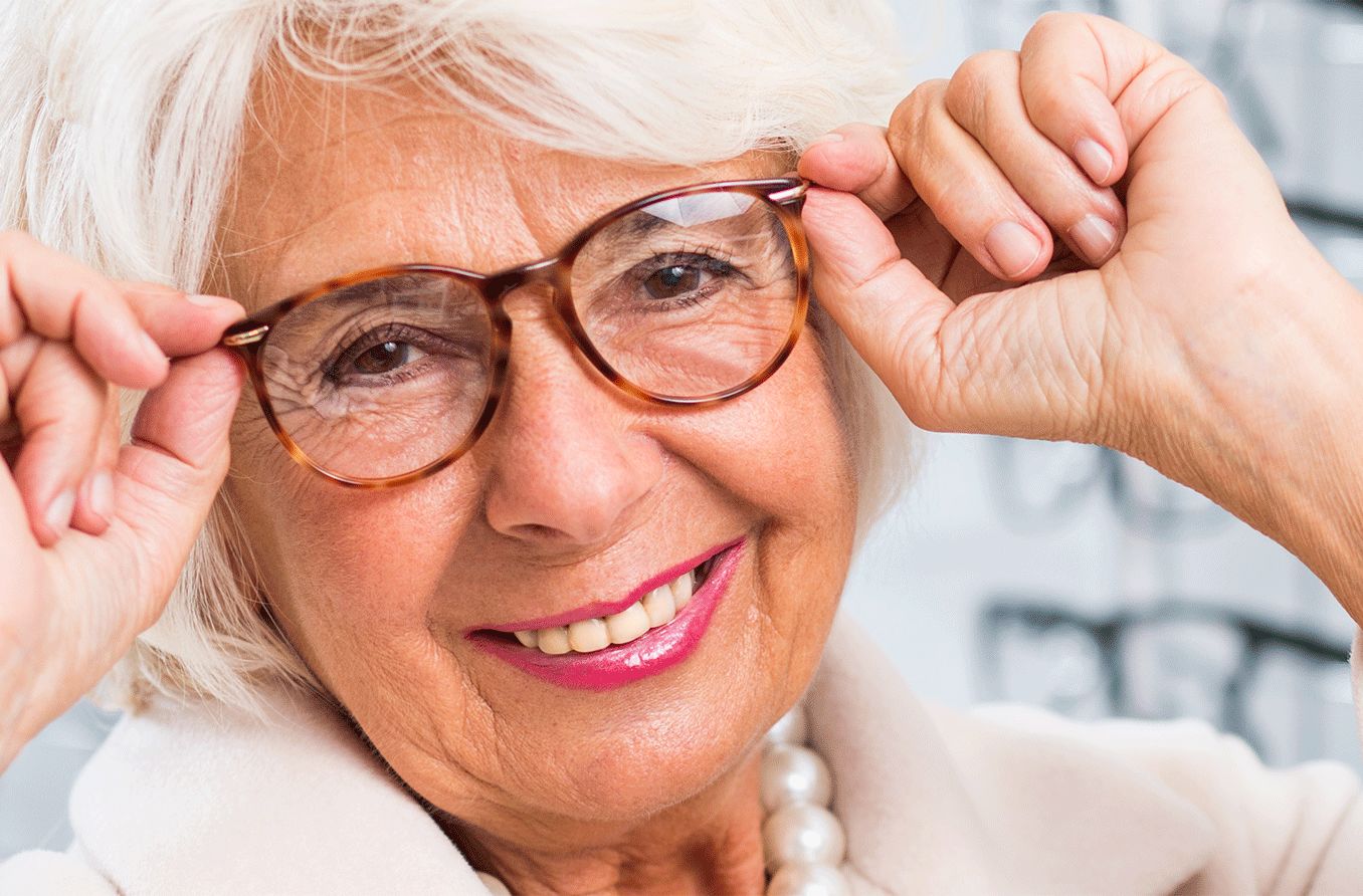 older woman trying on reading glasses and multifocals