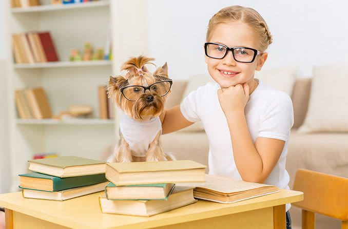 young girl wearing eyeglasses with her dog also wearing eyeglasses