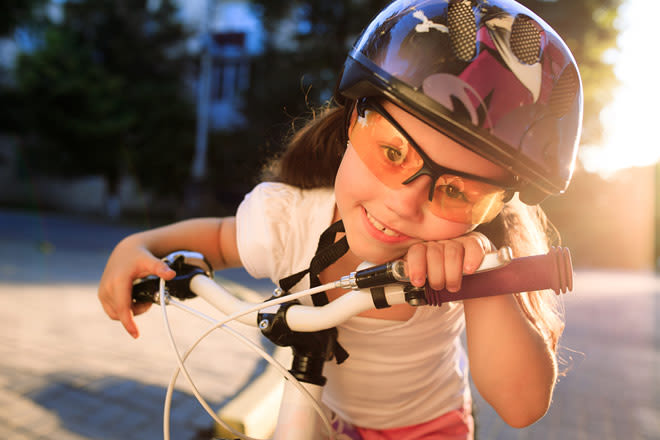 Little girl wearing trivex eyeglass lenses while riding a bike