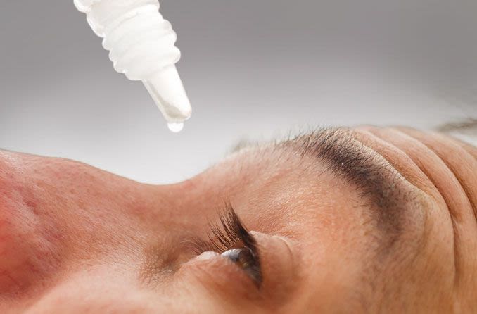 Man using eye drops for dry eyes