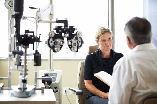 personne parlant à son médecin lors d'un examen de la vue