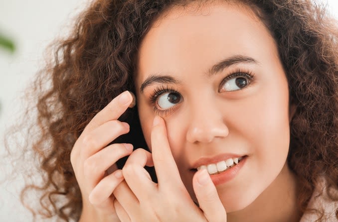 woman applying a contact lens