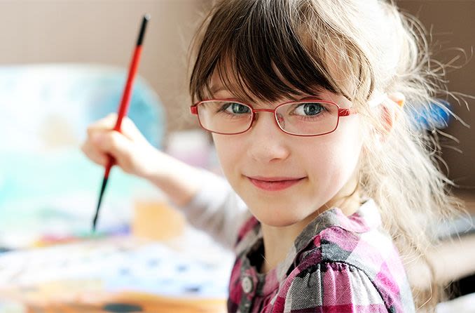 Preschool girl wearing eyeglasses while painting