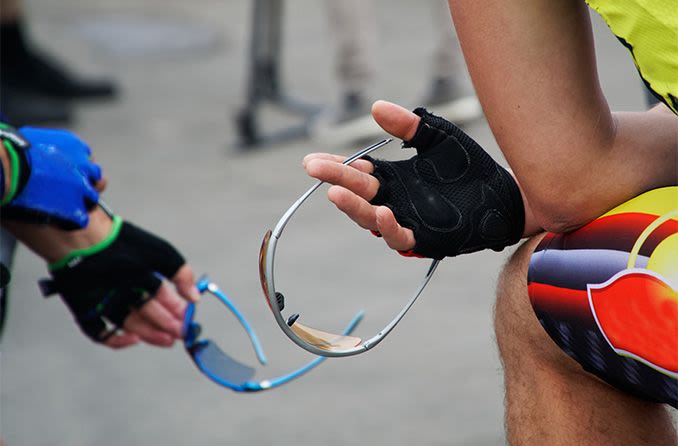 cyclists holding photochromic sunglasses
