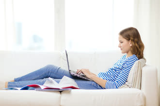 girl on couch using laptop computer