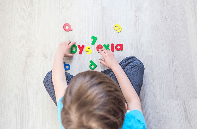 boy trying to put the letters together to spell dyslexia