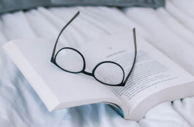 Brille für Weitsichtigkeit auf einem Buch
