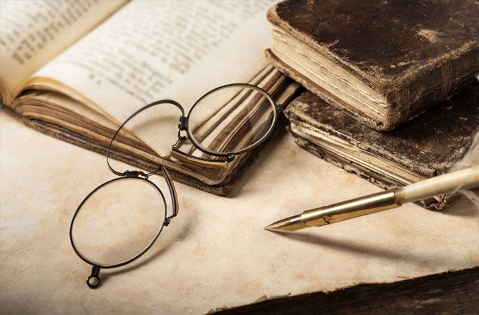 old fashioned eyeglasses on top of old books