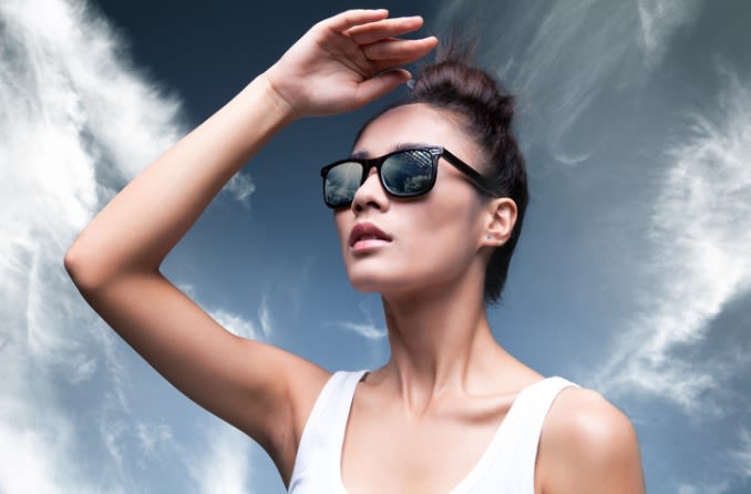 femme portant des lunettes de soleil tout en protégeant les yeux