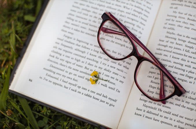 A pair of eyeglasses on top of an open book