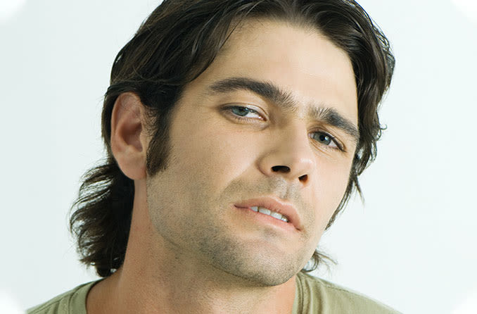man looking up to see better due to his droopy eyelids (ptosis)