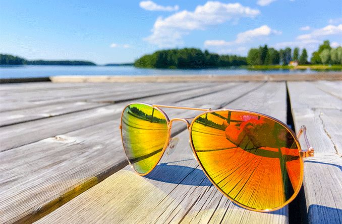 a pair of Quay sunglasses laying on a dock outside