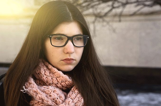 woman wearing glasses in the winter time wondering when the best time is it to get lasik surgery