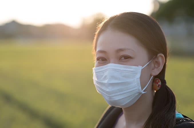 ウイルスの拡散を防ぐためにマスクを着用している女性