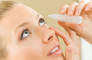 Woman using eye drops to aid Lasik recovery.