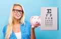 Woman looking at an eye chart and holding up a piggy bank wondering how much the eye exam cost