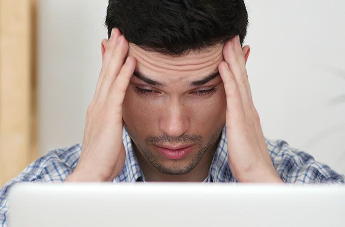 L'homme avec la fatigue oculaire de l'ordinateur en regardant l'écran d'un ordinateur portable