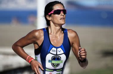 Athletic woman running while wearing sports sunglasses.
