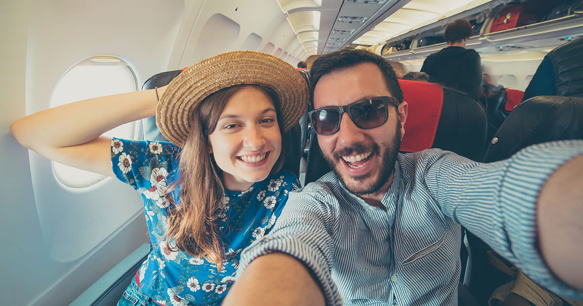 Jeune couple prenant un selfie dans un avion