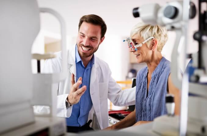 Doctor providing an eye exam to smiling patient