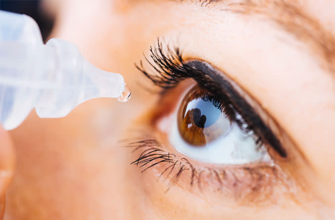 woman applying eye drops