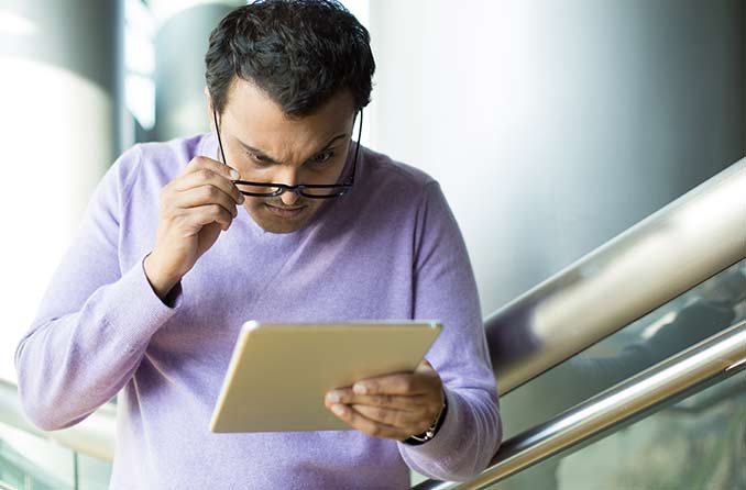 A woman wearing eyeglasses reading a book