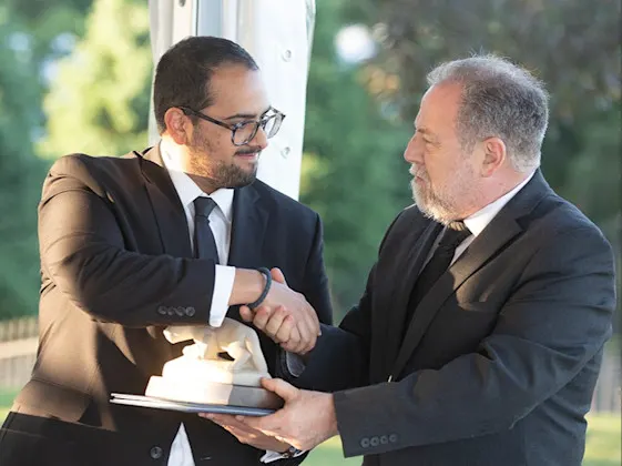 Dr. Danny Beauchamp accepts lion statue from Department Chair at fellowship graduation.