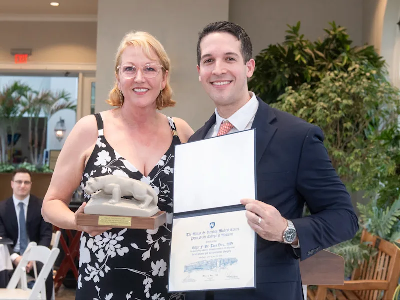 Dr. Edgar Del Toro Diez accepts certificate and lion statue from fellowship program director at graduation.
