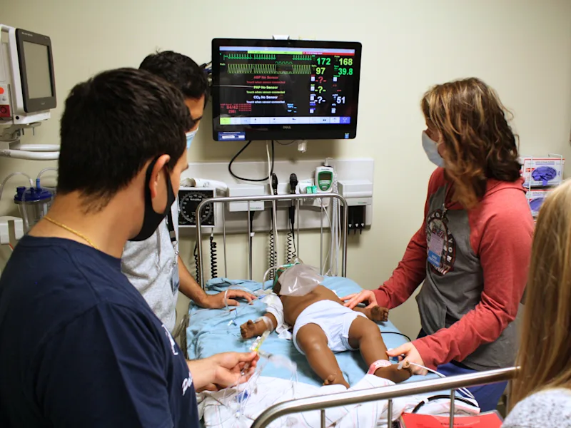 Healthcare professionals using robotic surgical simulation equipment at Penn State Hershey Clinical Simulation Center.