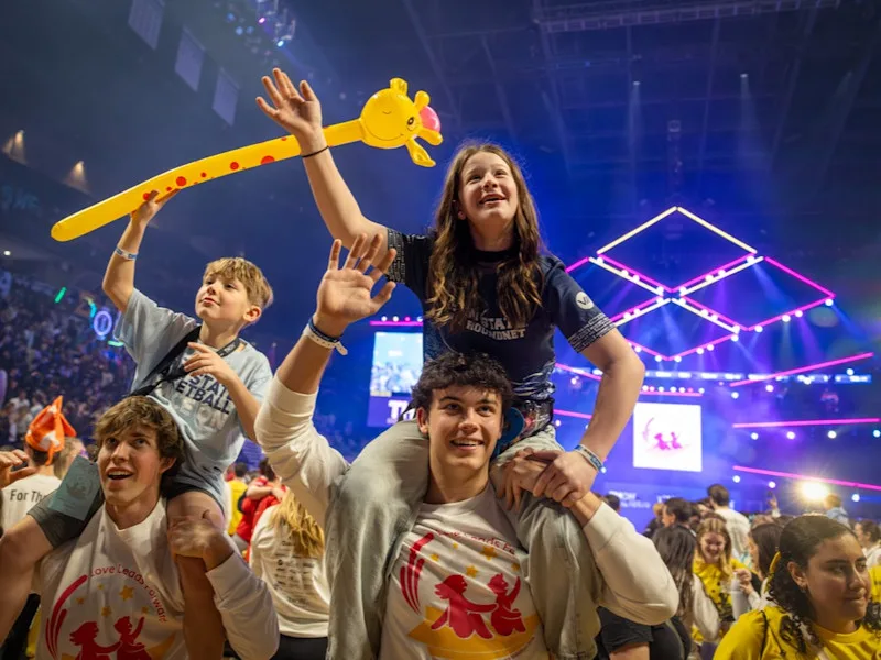 Devin Pulaski and her brother Trevor ride the shoulders of Kaden Gratton and Jake Hurst during the first night of THON 2026.