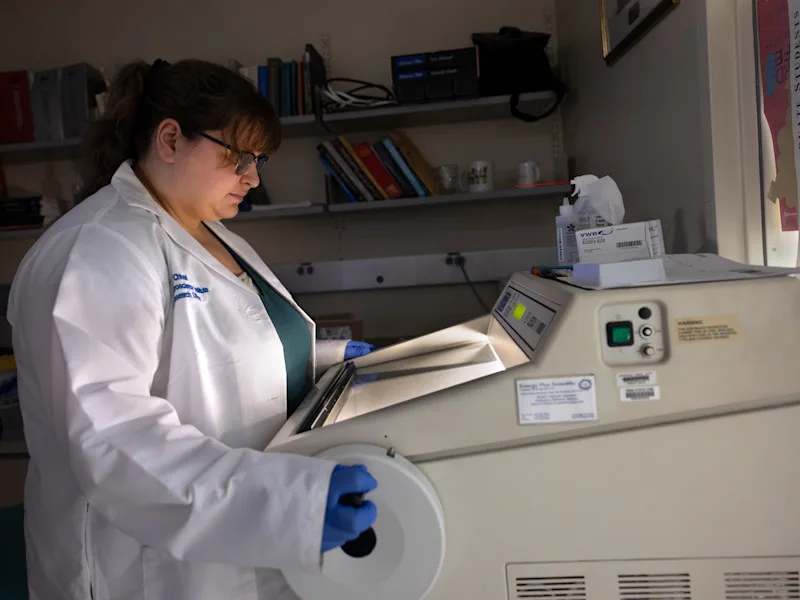 A lab technician operates a machine in the Neuroscience Institute lab