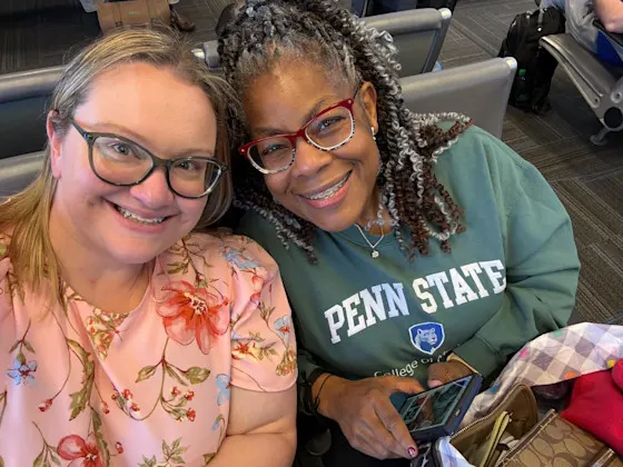 Two women, one wearing a Penn State College of Medicine sweatshirt, pose for a selfie