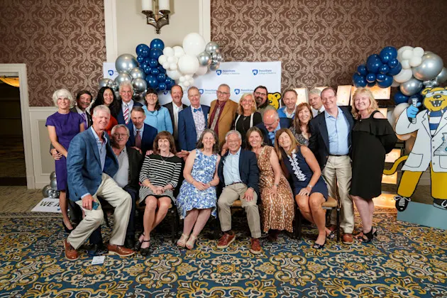 A reunion class from Alumni Weekend 2024 posing together in front of the picture opp area at the dinner reception.