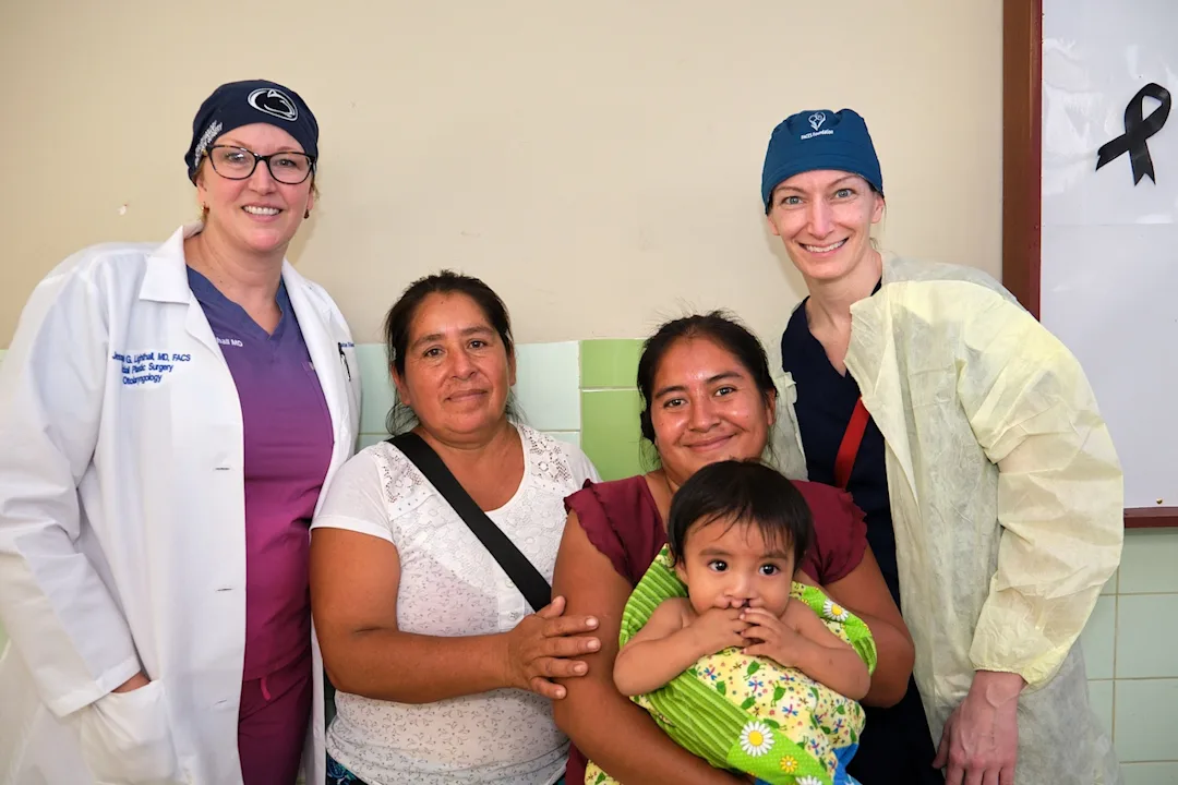 A family poses with otolaryngology surgeons after a successful operation